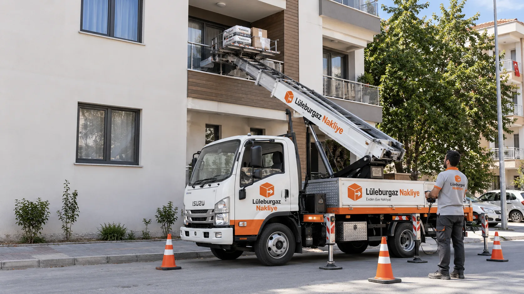 Balkona uzanan asansörlü nakliye aracı; operatör yerden platformu yönlendiriyor, çevrede emniyet konileri